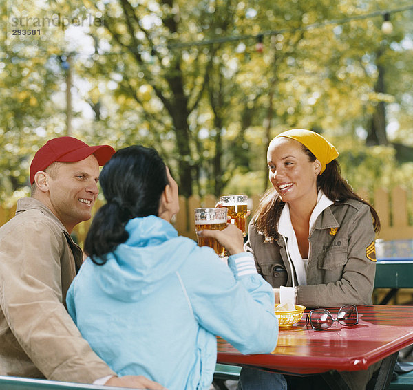 Drei Freunde in ein open-air-Restaurant.