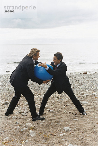 Zwei Männer kämpfen am Strand.