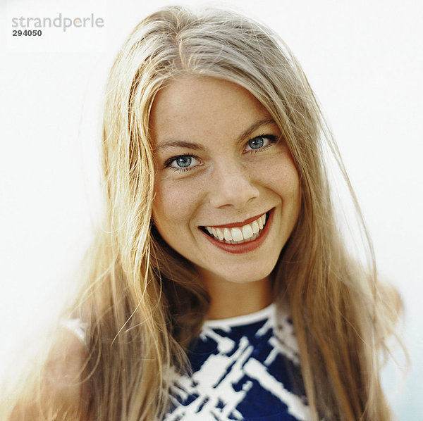Eine Lächelnde Frau mit langen blonden Haaren Portrait.