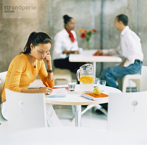 Eine Frau konzentrierten von einer Tabelle.