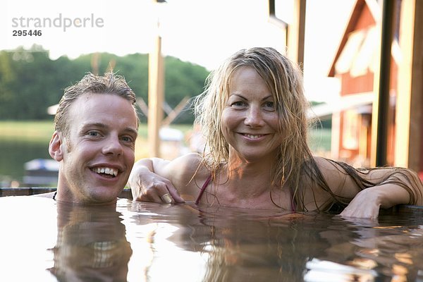 Ein Mann und eine Frau in einem Fass Außenaufnahme Baden.