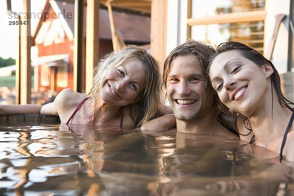 Zwei Frauen und ein Mann in einem Fass Außenaufnahme Baden.