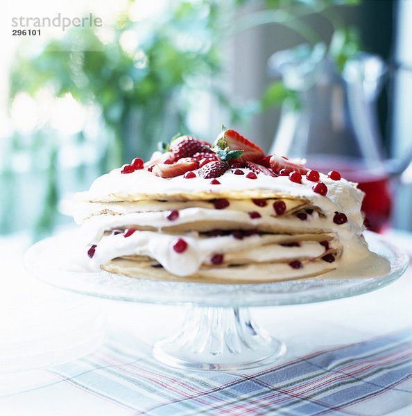 Ein Kuchen  hergestellt aus Palatschinken mit Erdbeeren und verschiedenen Beeren Nahaufnahme.
