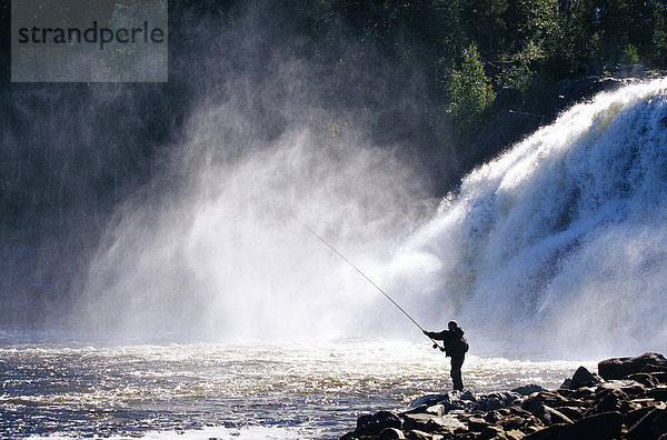 Ein Mann von einem Wasserfall Angeln.
