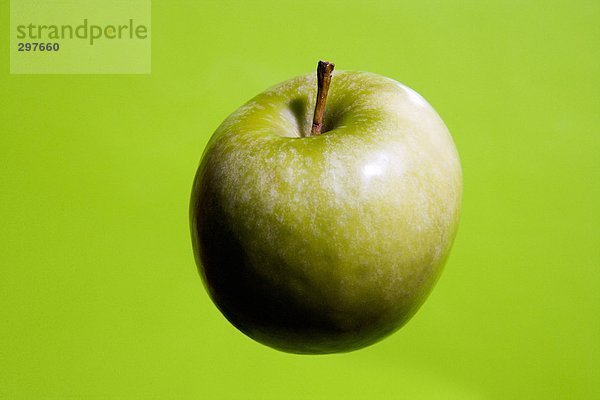 Ein grüner Apfel auf grünem Hintergrund.