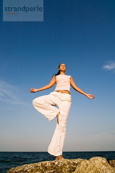 Young Frau macht Yoga-Übungen auf dem Seeweg