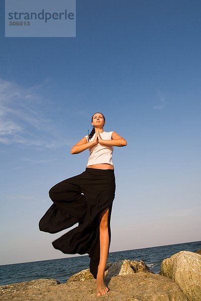 Young Frau macht Yoga-Übungen auf rock