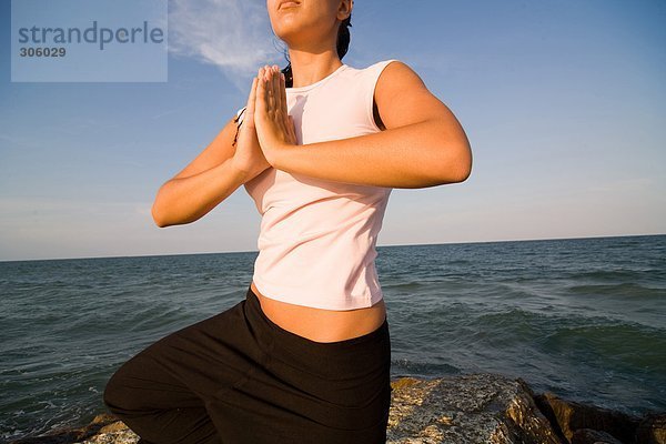 Young Frau macht Yoga-Übungen auf dem Seeweg