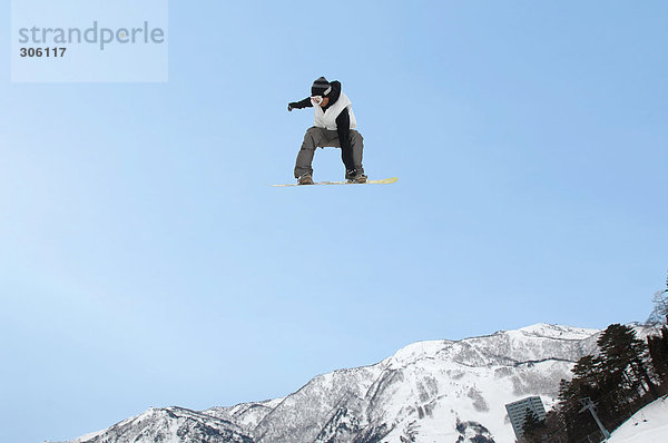 Junge Snowboarder airborne