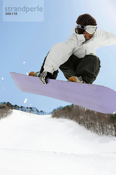 Junge Snowboarder Mitte Luft