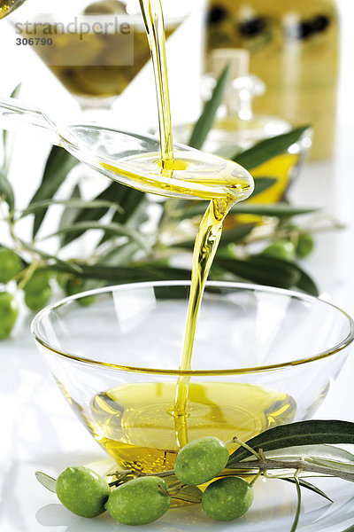 Frische grüne Oliven und Olivenöl in Glasschale
