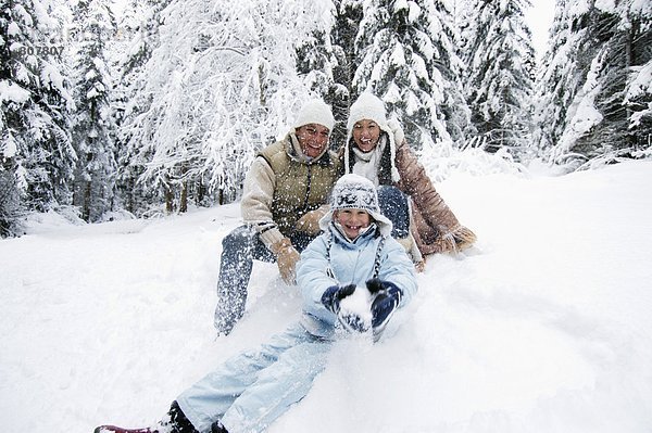Österreich  Salzburger Land  Junge (6-7) mit Familie im Schnee