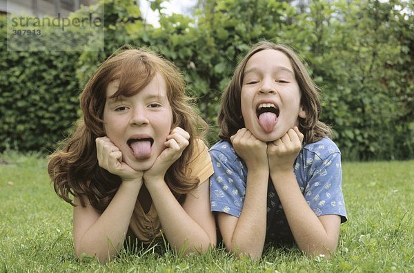 Kinder auf der Wiese im Garten liegend  Portrait