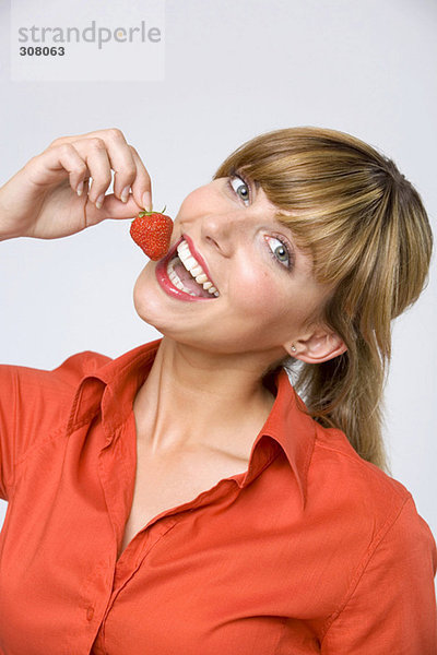 Junge Frau isst Erdbeere  Nahaufnahme