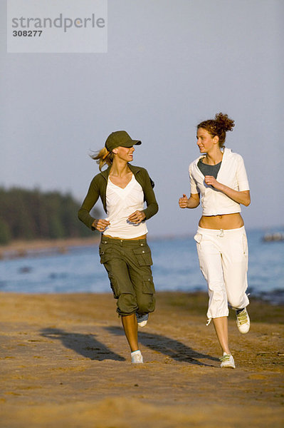 Zwei Frauen joggen am Strand