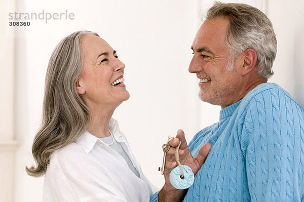 Erwachsenes Paar lächelnd  Mann mit Schlüssel  Nahaufnahme