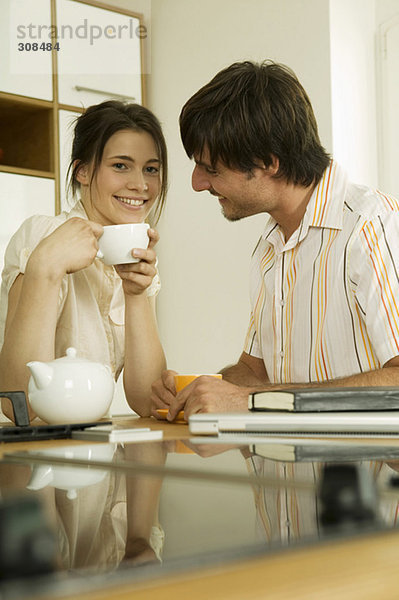 Junges Paar trinkt Tee in der Küche  lächelnd  Portrait