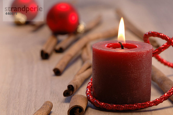 Weihnachtsdekoration mit brennenden Kerzen und Zimtstangen