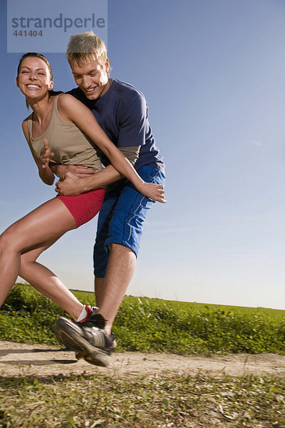 Young couple jogging  man catching woman