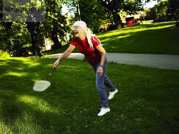 Eine Frau spielen Badminton Außenaufnahme.