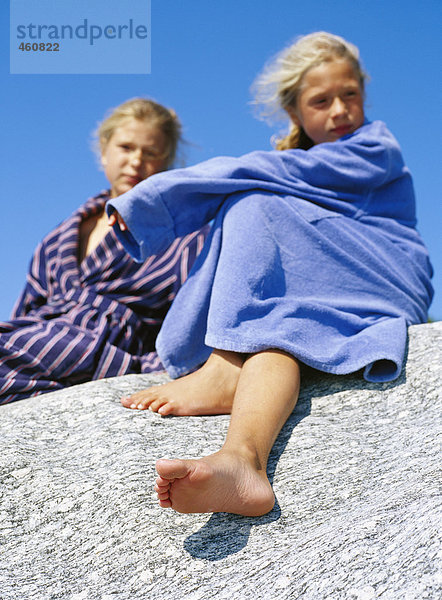 Zwei Schwestern auf einem Felsen.