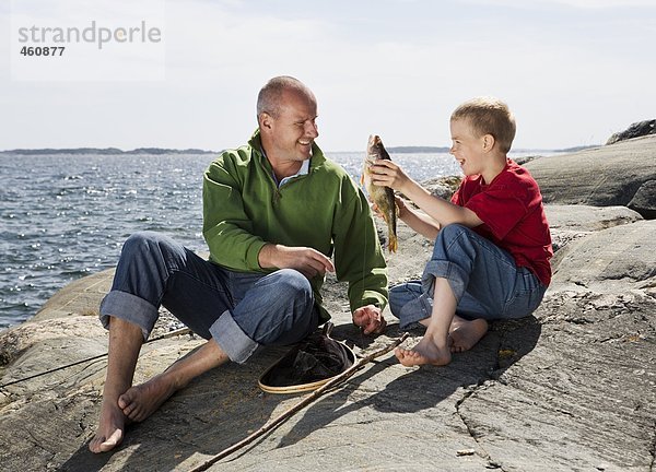 Vater und Sohn mit gefangenen Fische.