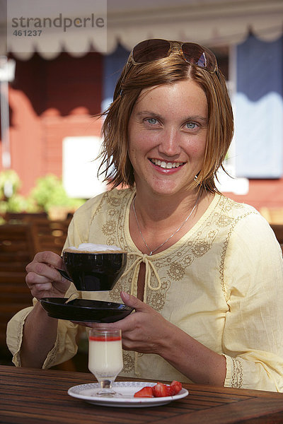 Eine Lächelnde Frau Kaffee zu trinken.