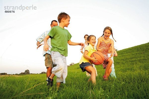 Familie spielen Basketball in Feld