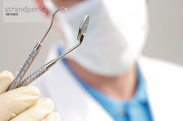 Nahaufnahme der männlichen Zahnarzt hält Plaque remover