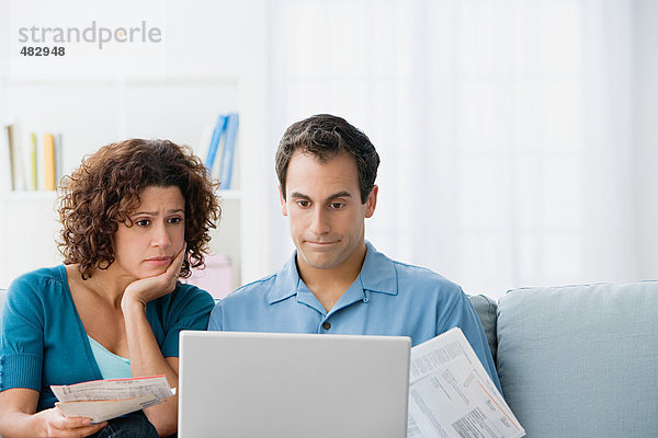 Paar  das sich die Finanzen zu Hause am Computer anschaut