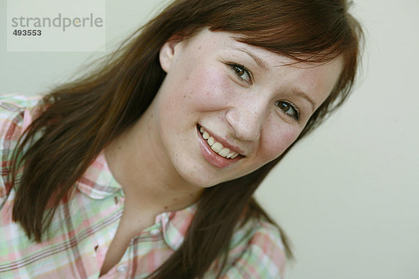 Portrait einer jungen Frau lächelnd.