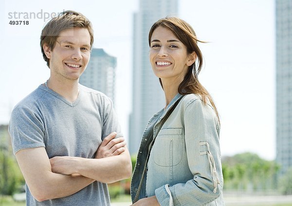 Junges Paar lächelt im Stadtgebiet