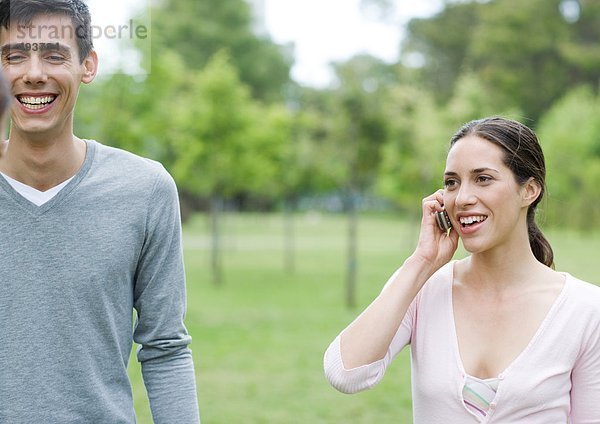 Freunde im Stadtpark  einer mit Handy