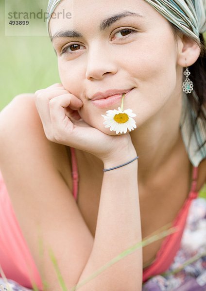 Junge Frau mit Blume im Mund  Portrait