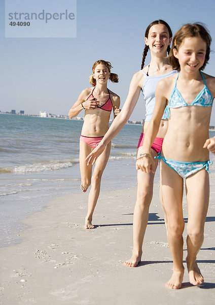Mädchen beim Laufen und Spazierengehen am Strand