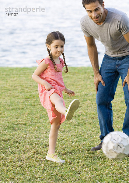 Mann spielt Fußball mit Tochter