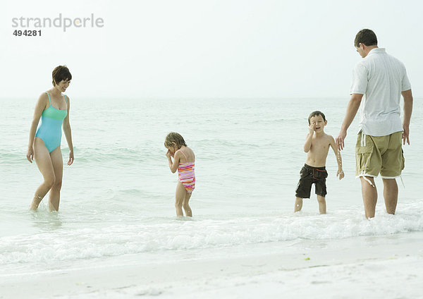 Familie am Strand  im Wasser stehend