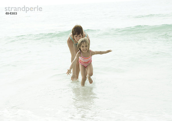 Mutter und Tochter im Wasser am Strand