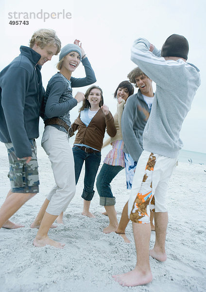 Gruppe junger erwachsener Freunde beim Tanzen am Strand