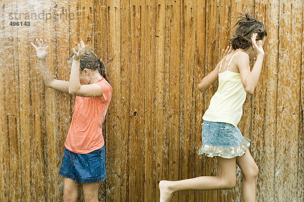 Mädchen werden nass in der Sprinkleranlage