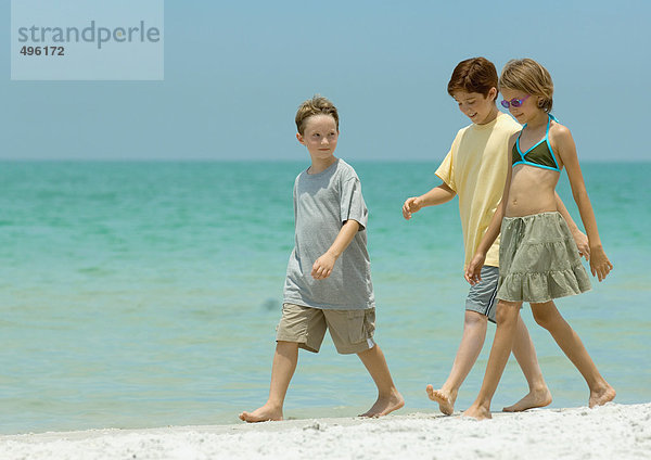 Drei Kinder beim Surfen am Strand