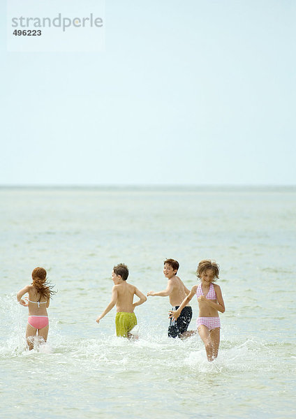 Kinder spielen im Meer