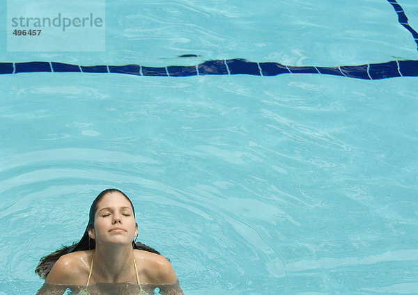 Frau im Pool stehend  Kopf hinten und Augen geschlossen  Frontansicht