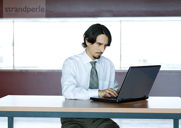Geschäftsmann mit Laptop am Schreibtisch