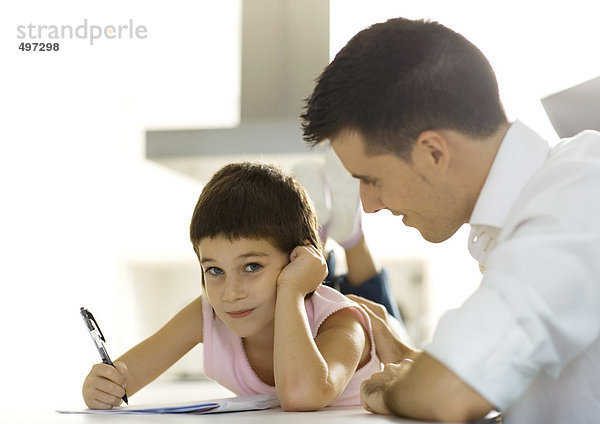 Vater hilft dem Kind bei den Hausaufgaben