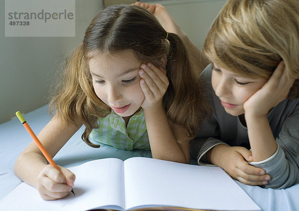 Zwei Kinder machen gemeinsam Hausaufgaben