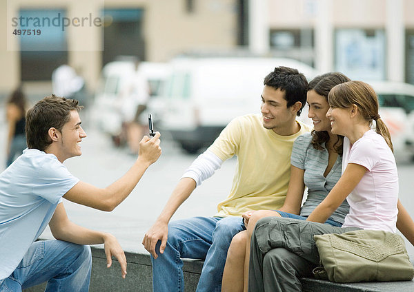 Teenager-Junge fotografiert Freunde mit dem Handy