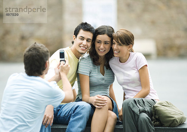 Teenager-Junge fotografiert Freunde mit dem Handy