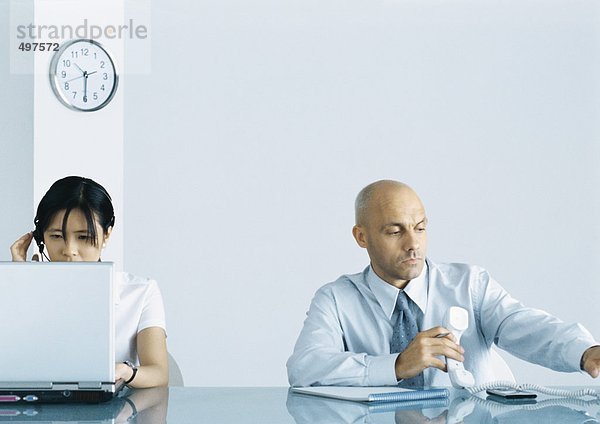 Büro  Mann mit Telefon und Frau mit Computer