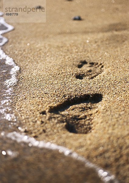 Fußabdrücke auf Sand am Strand